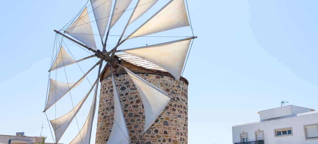 Traditionelle Windmühle in Antimachia auf Kos mit steinernem Turm und weißen Segeln.