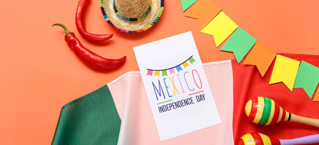 Grußkarte mit Text MEXIKO UNABHÄNGIGKEITSTAG, mexikanische Flagge, Maracas und Sombrero auf orangefarbenem Hintergrund