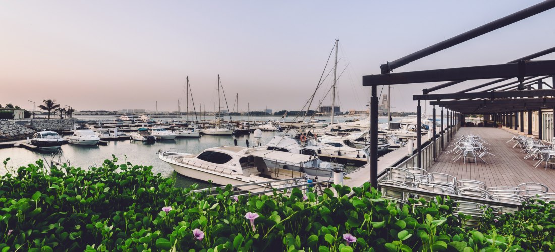 Yachthafen Al Hamra Marina in Ras Al Khaimah mit Terrasse, Yachten und moderner Promenade.