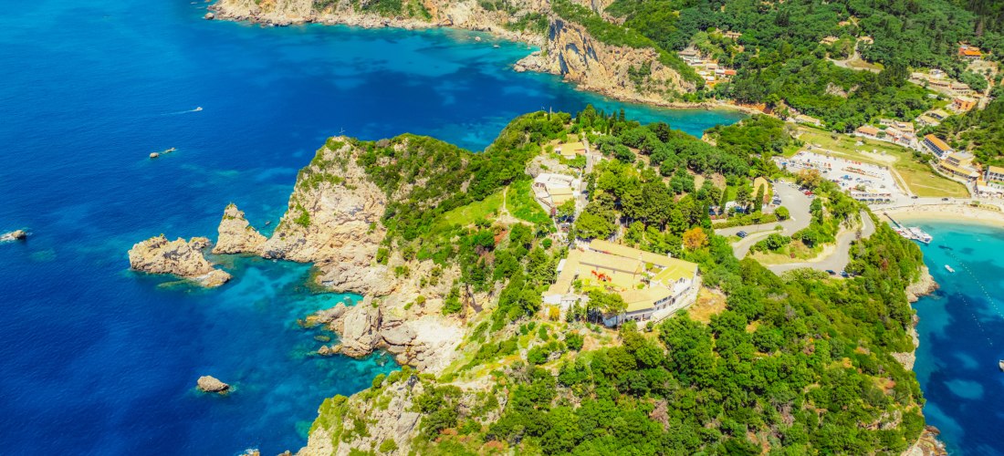 Luftaufnahme des Klosters Paleokastritsa auf Korfu, gelegen auf einer grünen Felsklippe über dem tiefblauen Meer