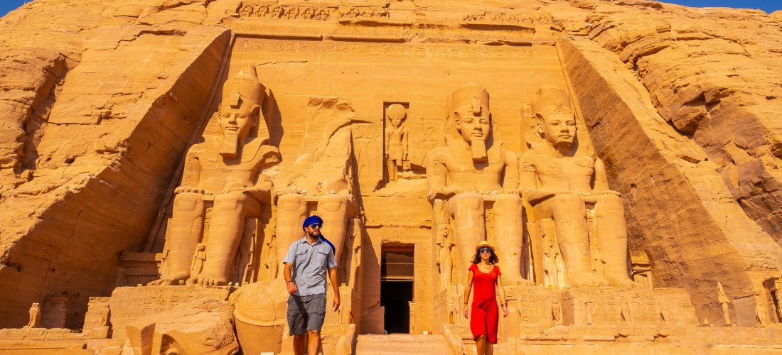 Ägypten - Abu Simbel Das Bild zeigt den imposanten Eingangsbereich des Großen Tempels von Abu Simbel in Südägypten. Vier riesige, sitzende Statuen von Pharao Ramses II. sind direkt in den Sandsteinfelsen gehauen. Zwischen den Statuen befindet sich der Tempeleingang. Zwei Tour