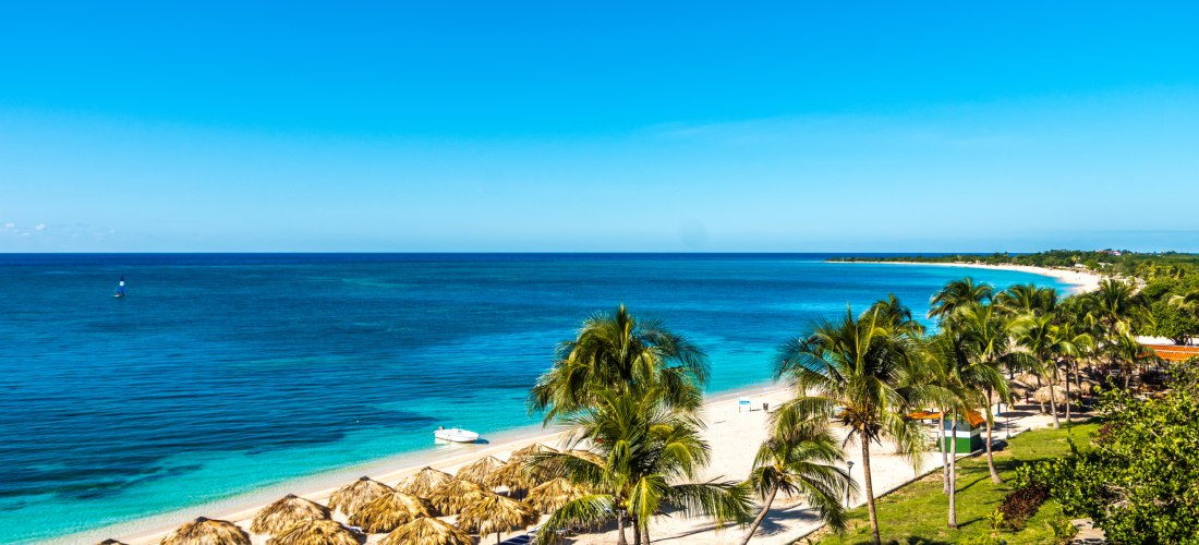 Playa Ancón – Karibischer Sandstrand bei Trinidad auf Kuba Panoramablick auf die Playa Ancón nahe Trinidad auf Kuba mit türkisblauem Meer, weißen Sandstränden, Palmen und Strohdächern – einer der schönsten Strände der Insel.