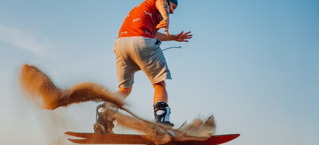 Tourist beim Sandboarding in der Wüste