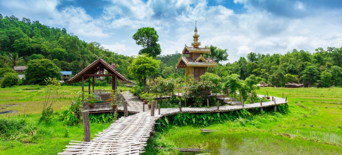 Bambusbrücke und Tempel in Pai – Tradition trifft Natur in Nordthailand Traditionelle Bambusbrücke mit kleinem Tempel und Reisfeldern in Pai, Nordthailand