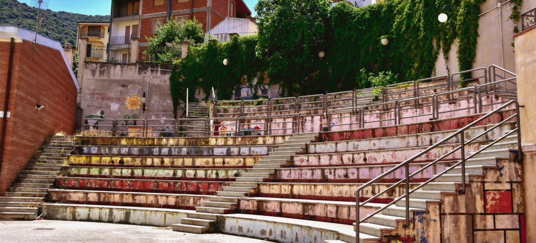 Freiluft-Amphitheater in Orgosolo auf Sardinien mit bunten Häusern und grüner Umgebung – authentisches Bergdorf im Herzen der Insel, bekannt für Wandmalereien
