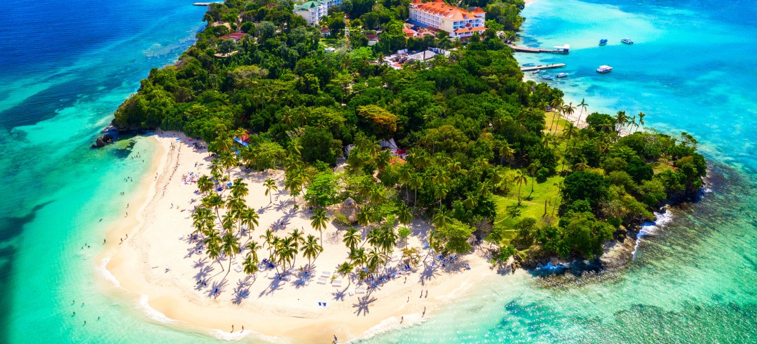 Luftaufnahme einer tropischen Insel in der Dominikanischen Republik mit weißen Sandstränden, türkisblauem Meer und grünen Palmen – paradiesisches Reiseziel