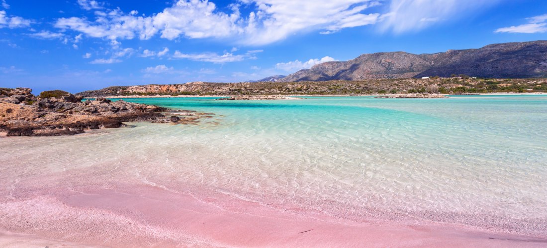 Strand mit türkisfarbenem Wasser und rosa Sand