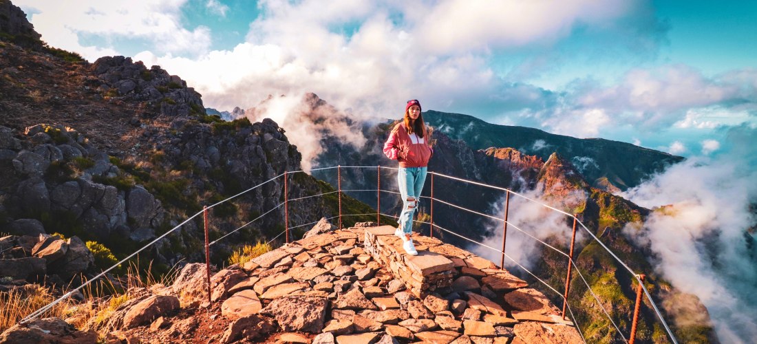 Pico do Arieiro Madeira – Wanderung über den Wolken auf dem Gipfel Frau auf dem Gipfel des Pico do Arieiro auf Madeira mit Blick auf die Berge und Wolkenlandschaft im Sonnenlicht