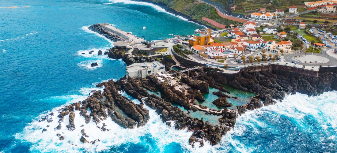Porto Moniz Madeira – Küstenort mit Lavabecken und Atlantikblick Luftaufnahme von Porto Moniz auf Madeira mit Lavapools, Küstenstraße und türkisblauem Atlantik