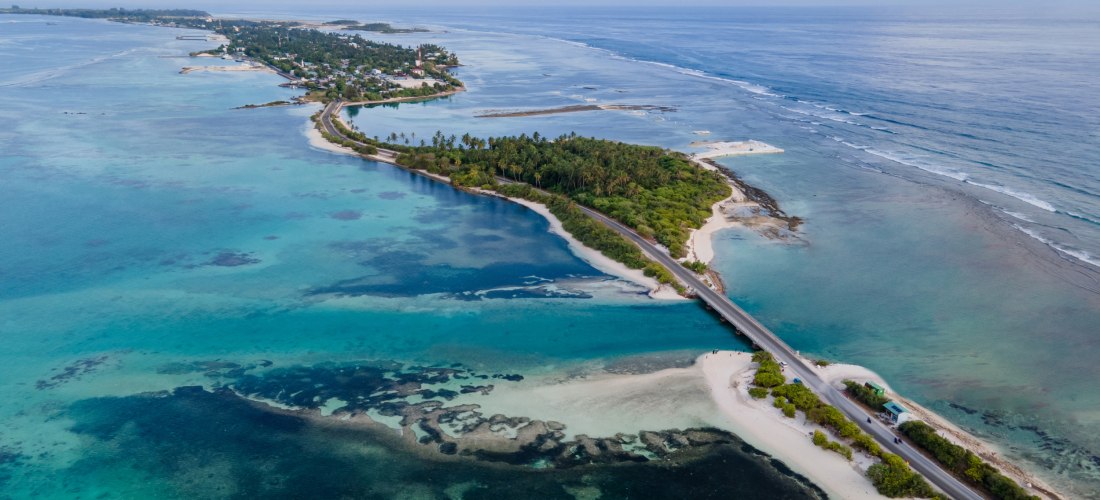 Luftaufnahme von der Insel Hulhumalé, Malediven – Brücke verbindet die Insel mit dem Festland, türkisfarbenes Meer und Strände