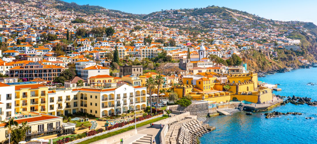 Funchal Madeira – Altstadt  Blick auf die Altstadt von Funchal auf Madeira mit bunten Häusern, Hafenpromenade und Atlantikküste bei Sonnenschein