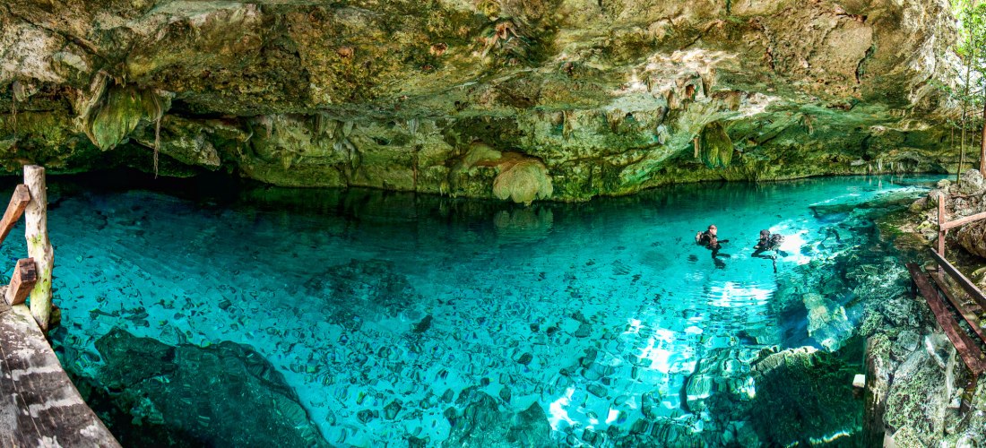 Zwei Taucher erkunden eine Cenote in Mexiko – Höhle mit glasklarem Wasser und Felsen, beliebtes Ausflugsziel auf der Halbinsel Yucatán 2025/2026