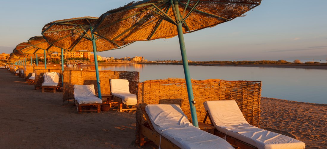 Strand in El Gouna, Sonnenschirme, Windschutz, Liegen, Wasser, blauer Himmel, einladend zum entspannen..