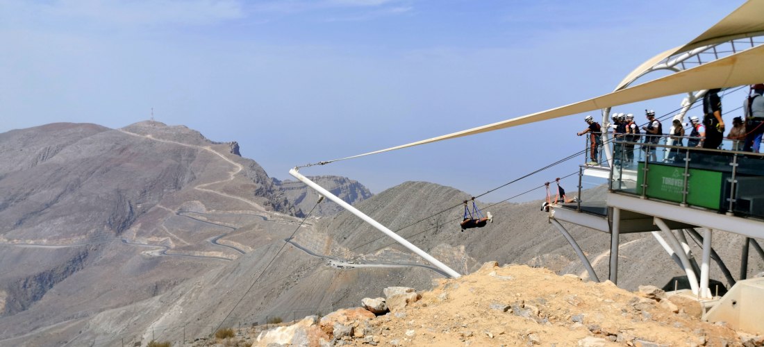 Jebel Jais Zipline in Ras Al Khaimah – Plattform mit Besuchern und Start der längsten Zipline der Welt über das Hadschar-Gebirge.