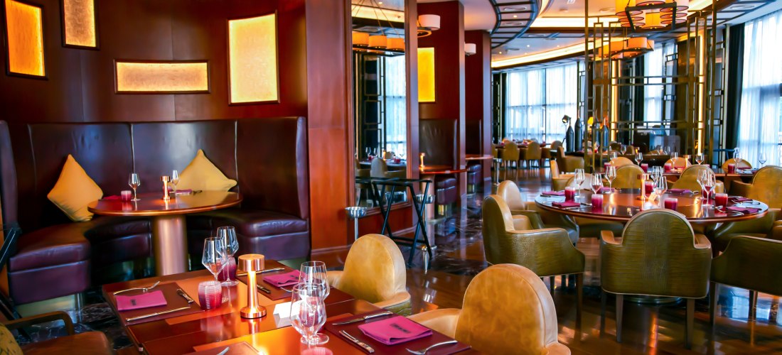 Elegantes Restaurant mit stilvoller Beleuchtung, edlen Holzmöbeln und gedeckten Tischen
