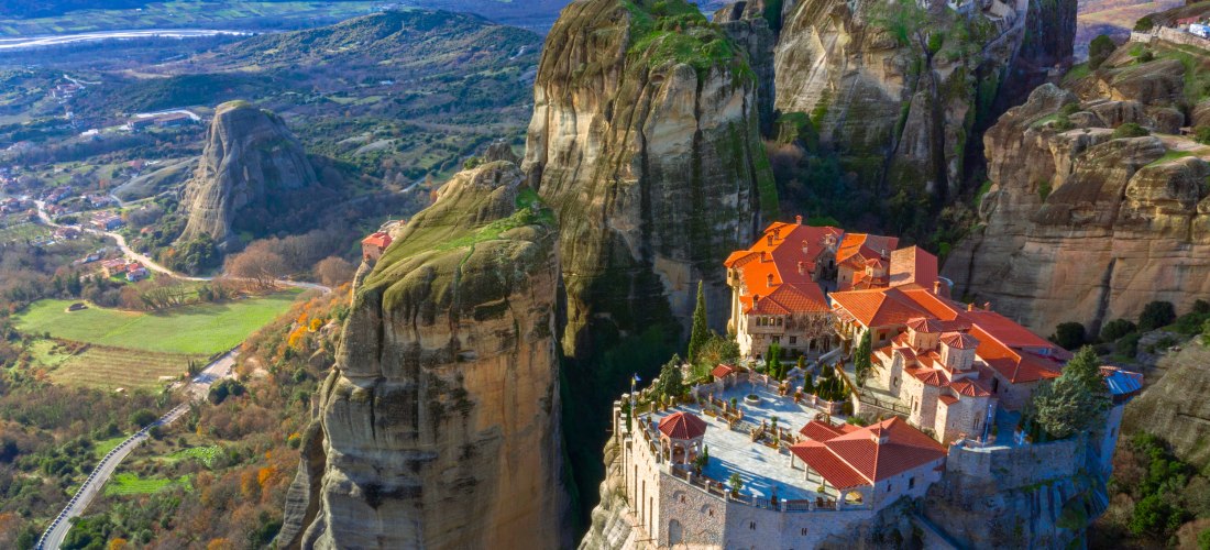 Blick auf die Meteora-Klöster in Griechenland, erbaut auf steilen Sandsteinfelsen mit roten Dächern