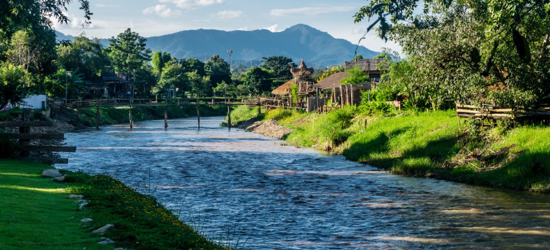 Naturparadies Pai – Idyllische Flusslandschaft im Norden Thailands Ruhiger Fluss in Pai umgeben von grüner Natur und Bergen in Nordthailand