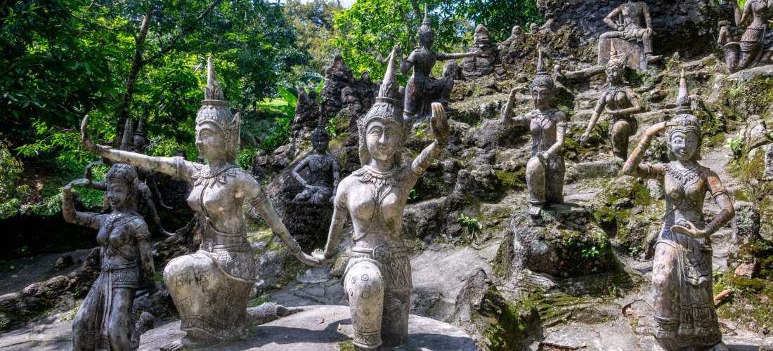 Steinerne Figuren und mystische Statuen im Magic Garden von Koh Samui, Thailand, umgeben von tropischer Natur und dichter Vegetation.
