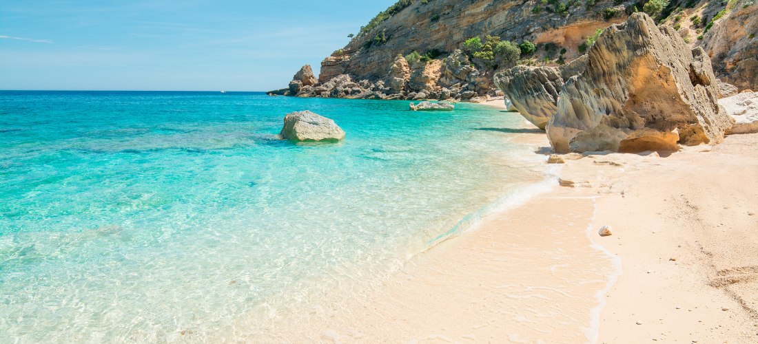 Traumstrand Cala Mariolu auf Sardinien mit weißem Sand, türkisblauem Wasser und Felsen an der Ostküste – einer der schönsten Orte der Insel