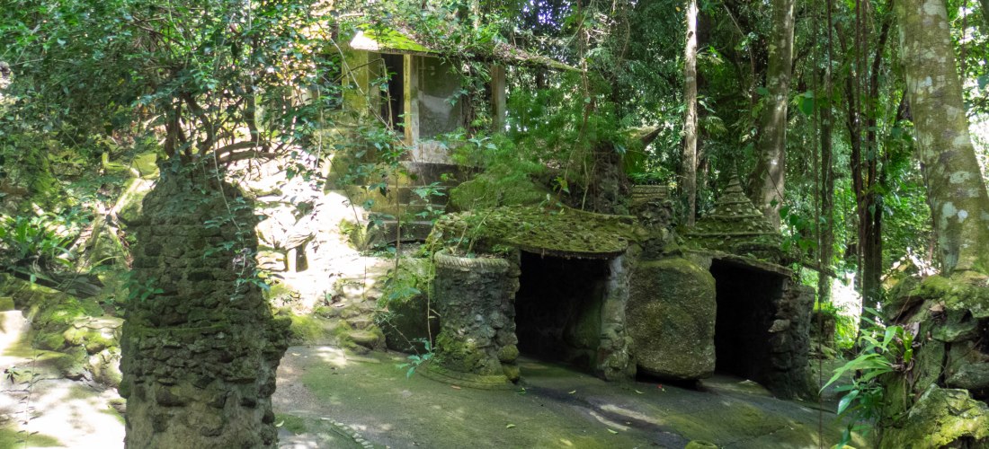 Moosbewachsene Steinskulpturen und kleine Tempel im Secret Buddha Garden auf Koh Samui, Thailand, verborgen im dichten Dschungel der Insel.