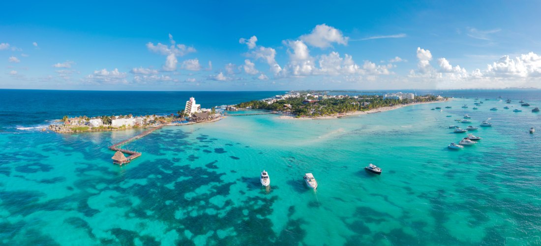 Luftaufnahme der Isla Mujeres in Mexiko mit weißen Stränden, türkisfarbenem Meer und Yachten – beliebtes Karibikziel 2025/2026