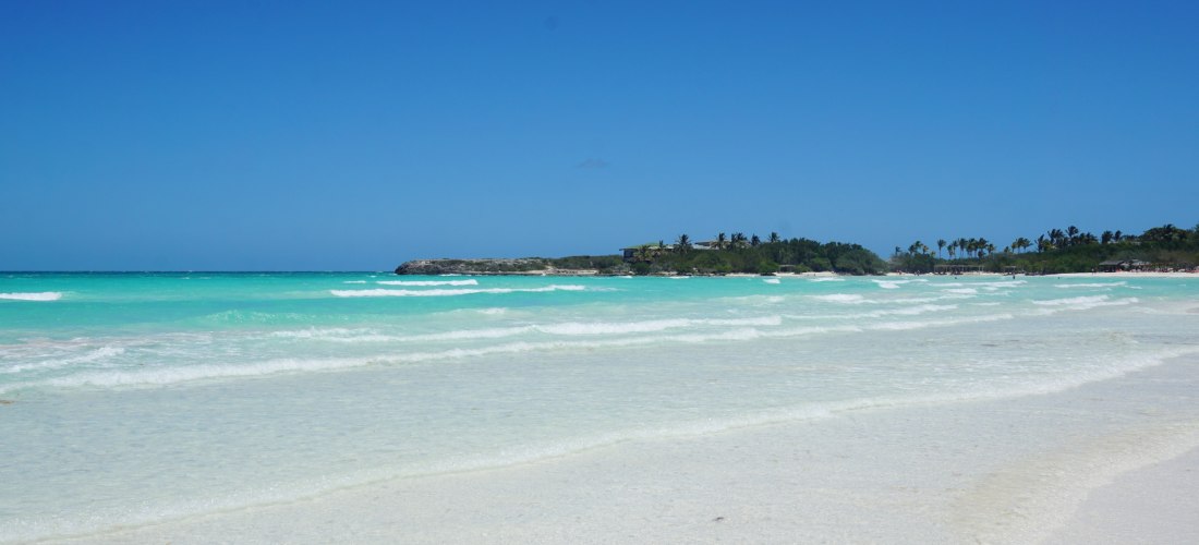 Cayo Coco – türkisblaues Meer und feiner weißer Sand in Kuba Panoramablick auf den traumhaften Strand auf Kuba mit türkisblauem Meer, sanften Wellen, weißem Sandstrand und Palmen im Hintergrund unter klarem, blauem Himmel.