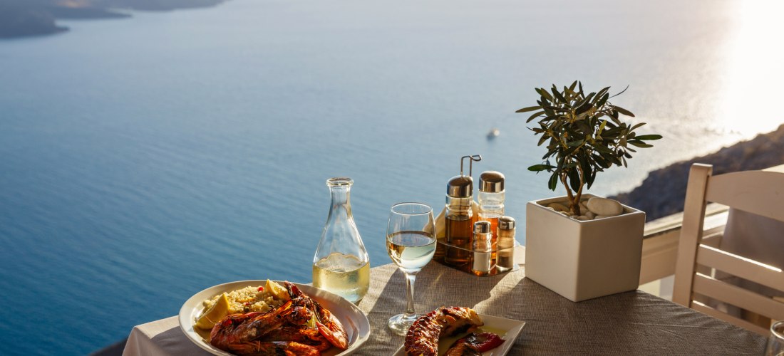 Griechische Köstlichkeiten auf einem Tisch mit Blick aufs Meer