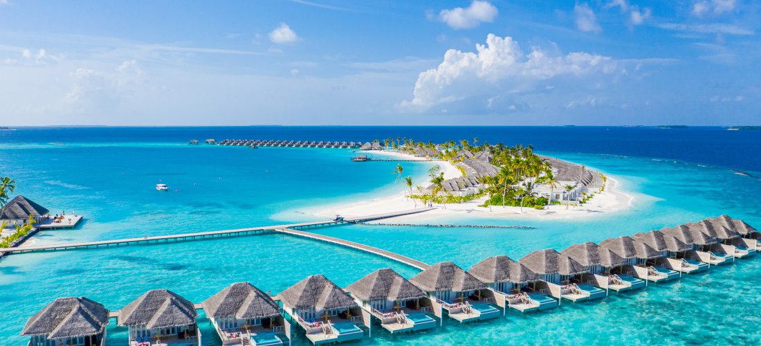 Ein atemberaubendes Luxusresort auf einer tropischen Insel mit eleganten Wasservillen, weißem Sandstrand und kristallklarem Meer.Perfekt für einen exklusiven Traumurlaub inmitten paradiesischer Natur.