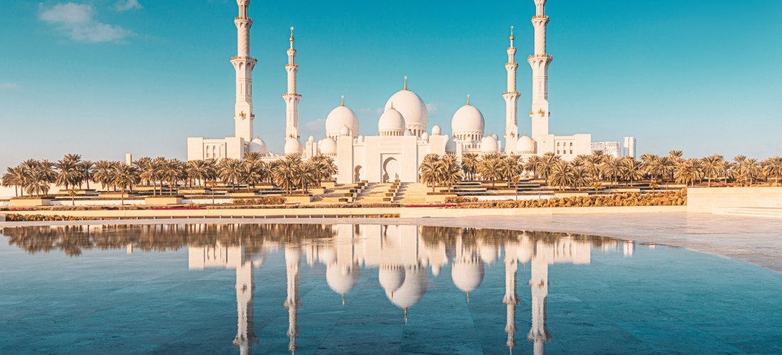 Sheikh Zayed Moschee in Abu Dhabi mit Spiegelung im Wasser bei blauem Himmel