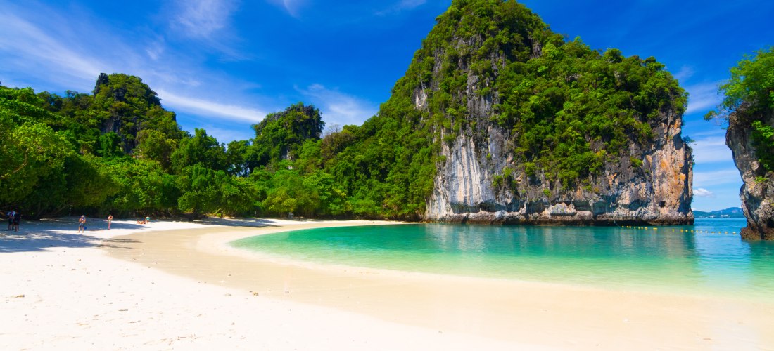 Hong Island bei Krabi, Thailand: idyllische Sandbucht mit türkisfarbenem Meer, grüner Vegetation und Kalksteinfelsen.