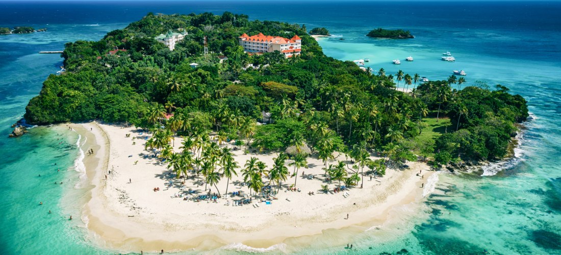 Tropische Insel bei Samaná in der Dominikanischen Republik mit weißen Sandstränden, Palmen, türkisfarbenem Meer und einem Hotel im Hintergrund