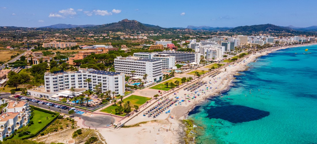 Luftaufnahme von Cala Millor auf Mallorca mit Strandpromenade, Hotels, Sandstrand und türkisblauem Meer