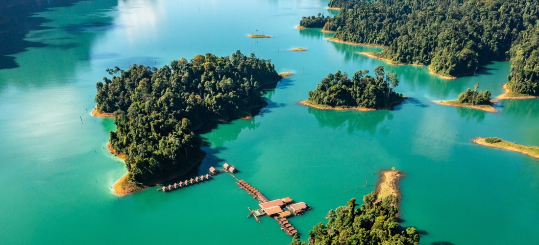 Cheow Lan Lake im Khao Sok – Spektakuläre Natur und schwimmende Resorts Luftaufnahme vom Cheow Lan Lake mit Inseln, Dschungel und schwimmenden Bungalows im Khao Sok Nationalpark, Thailand