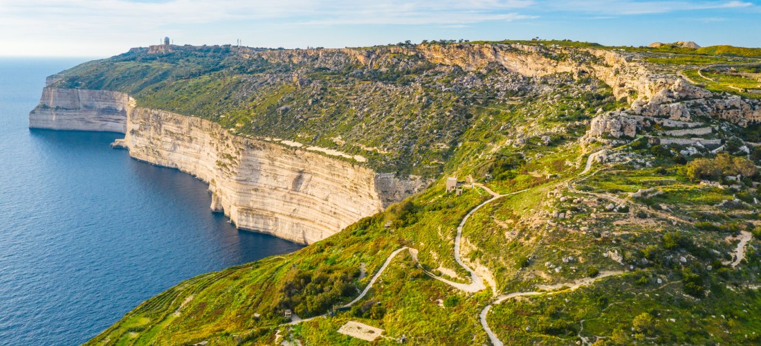 Luftaufnahme der Dingli Cliffs auf Malta mit Wanderwegen, grüner Landschaft und Blick auf das tiefblaue Meer