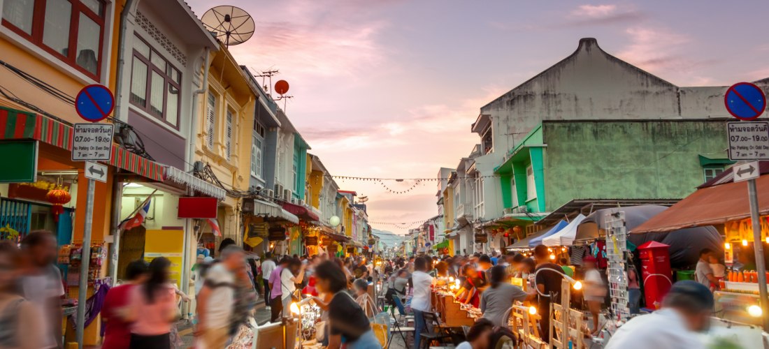 Lebhafter Nachtmarkt in der Altstadt von Phuket Town mit bunten Häusern und Streetfood-Ständen