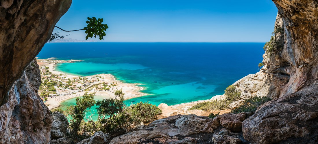 Blick aus einer Höhle auf eine Bucht und Blick auf das Meer