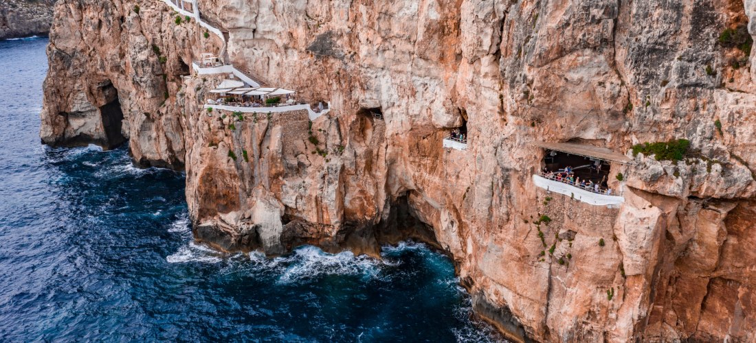 Bar und Aussichtsplattformen der Höhlen-Disco Cova d'en Xoroi, die spektakulär in eine steile Felswand über dem Meer auf Menorca gebaut ist.