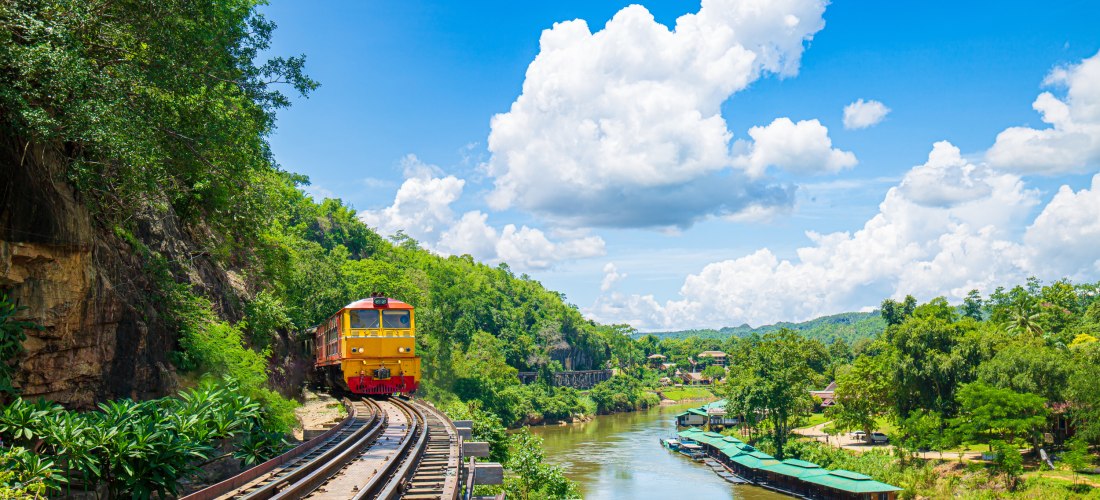 Zugfahrt auf der Todesbahn in Kanchanaburi – Eisenbahnbrücke am River Kwai, Thailand Historischer Zug auf der berühmten Death Railway in Kanchanaburi über den River Kwai in Thailand