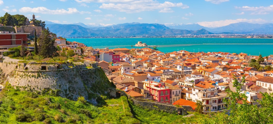 Blick auf Nafplio mit venezianischer Festung, roten Dächern und dem türkisfarbenen Meer im Hintergrund