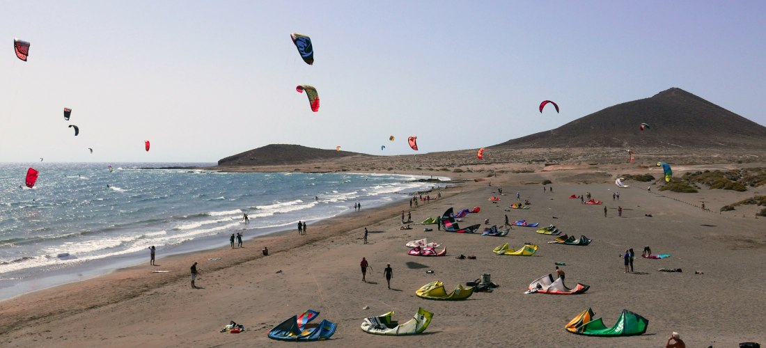 Kitesurfer am Strand von El Médano mit Montaña Roja im Hintergrund auf Teneriffa