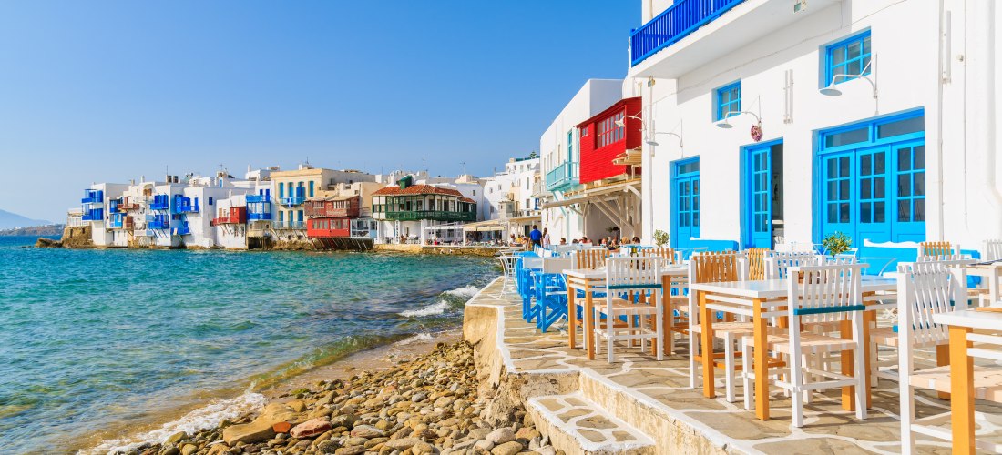 Bunte Häuser und weiße Fassaden im Viertel Little Venice auf Mykonos mit Restaurants direkt am Meer