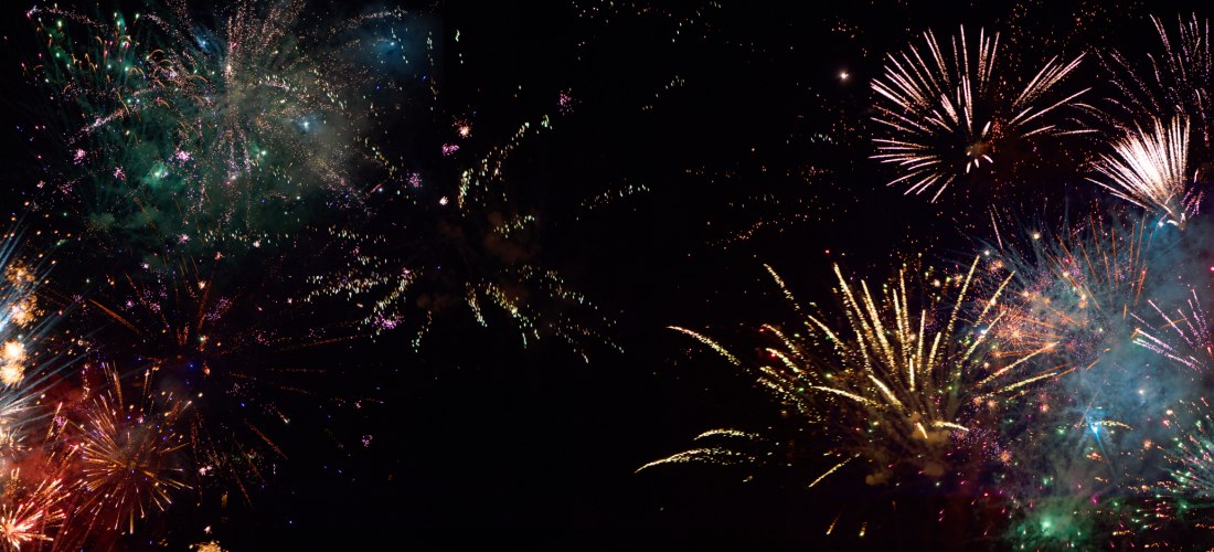 Farbenfrohes Feuerwerk am Nachthimmel mit funkelnden Lichtern und Rauch