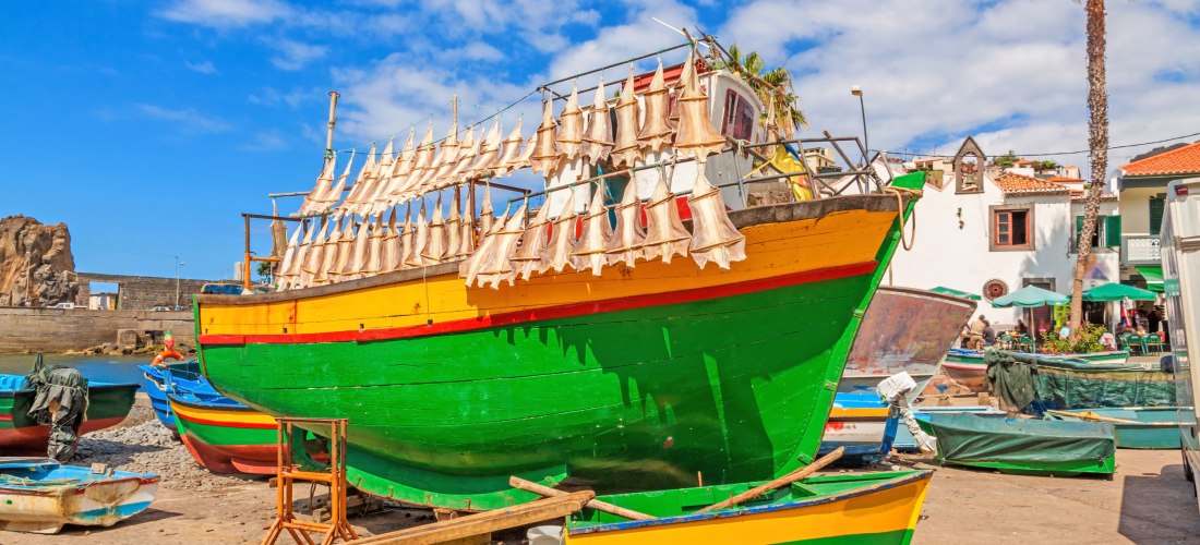Câmara de Lobos Madeira – Bunte Fischerboote und Trockenfisch Buntes Fischerboot mit aufgehängtem Trockenfisch in Câmara de Lobos auf Madeira bei blauem Himmel