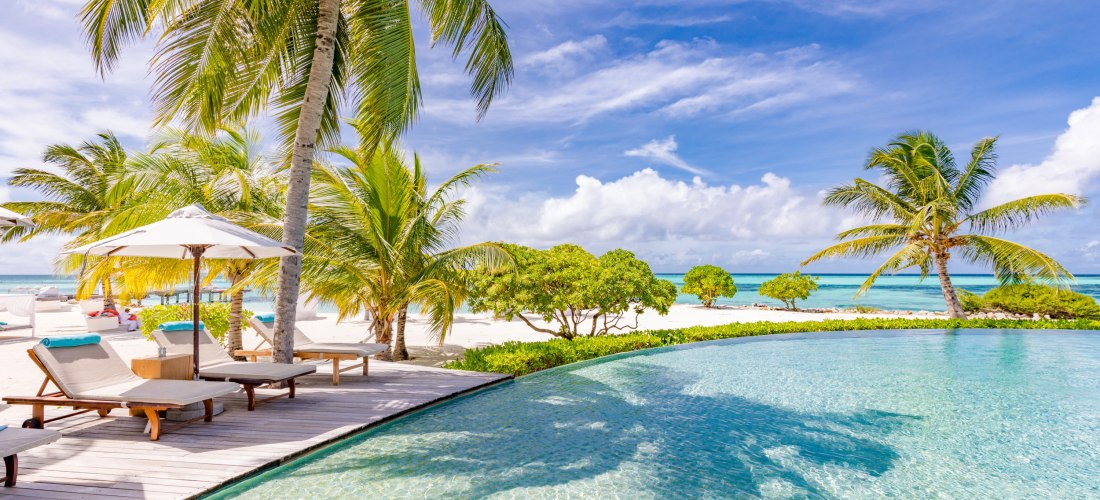 Infinity-Pool am Meer mit untergetauchten Liegen in einem Luxusresort