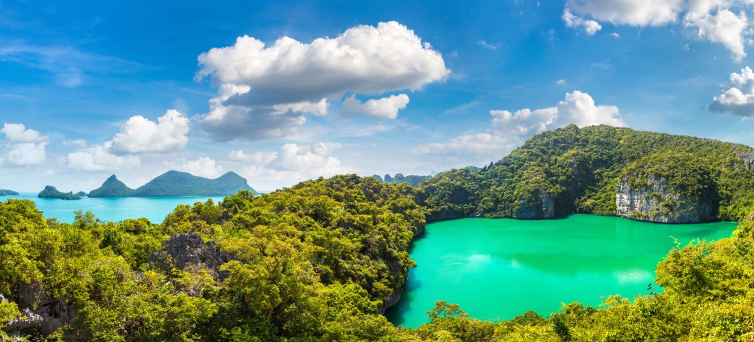 Panoramaaufnahme des smaragdgrünen Emerald Lake im Ang Thong National Marine Park nahe Koh Samui, umgeben von üppigem Dschungel und Kalksteinfelsen.