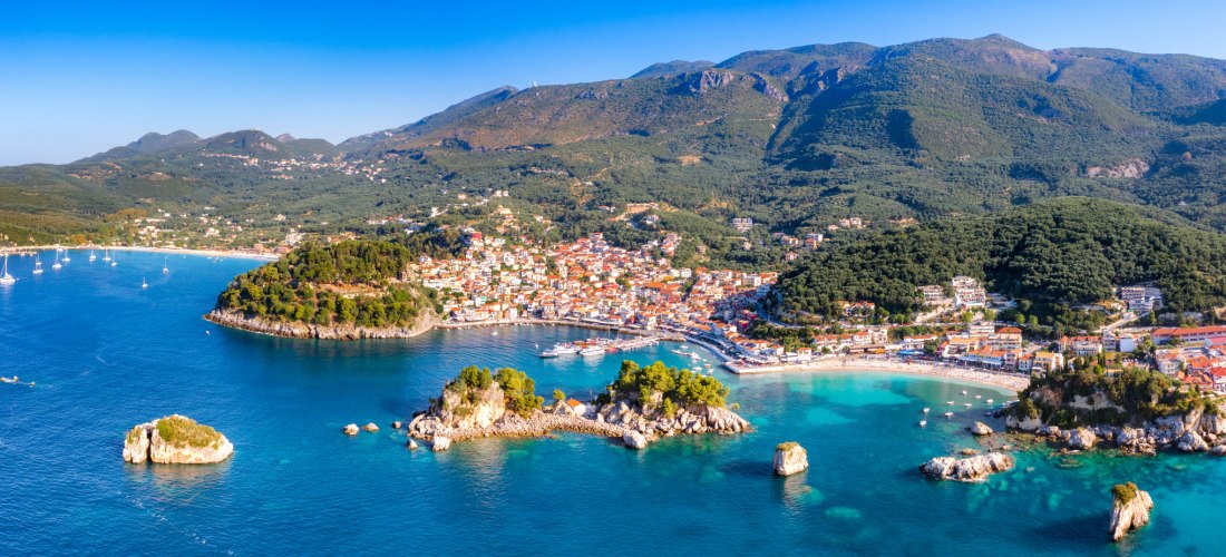 Luftaufnahme von Parga in Griechenland mit Stränden, türkisfarbenem Meer und grünen Hügeln im Hintergrund