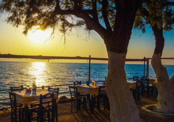Blick auf die Tische in der Taverne am Meer bei Sonnenuntergang