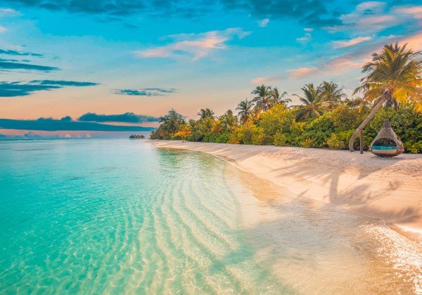 Willkommen im Paradies! Dieses atemberaubende Bild zeigt einen unberührten weißen Sandstrand, umgeben von üppigen Palmen und tropischer Vegetation. Das kristallklare, türkisfarbene Wasser glitzert in der Sonne, während sanfte Wellen die Küste berühren.Ein