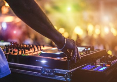 DJ bedient Mischpult bei einer Party auf Ibiza
