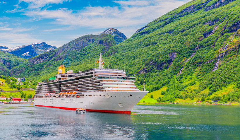 Kreuzfahrtschiff im Geirangerfjord vor grünen Berghängen